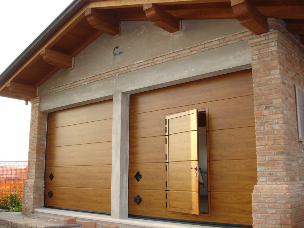 Porta per garage sezionale simil legno con porta pedonale per ingresso a piedi facilitato