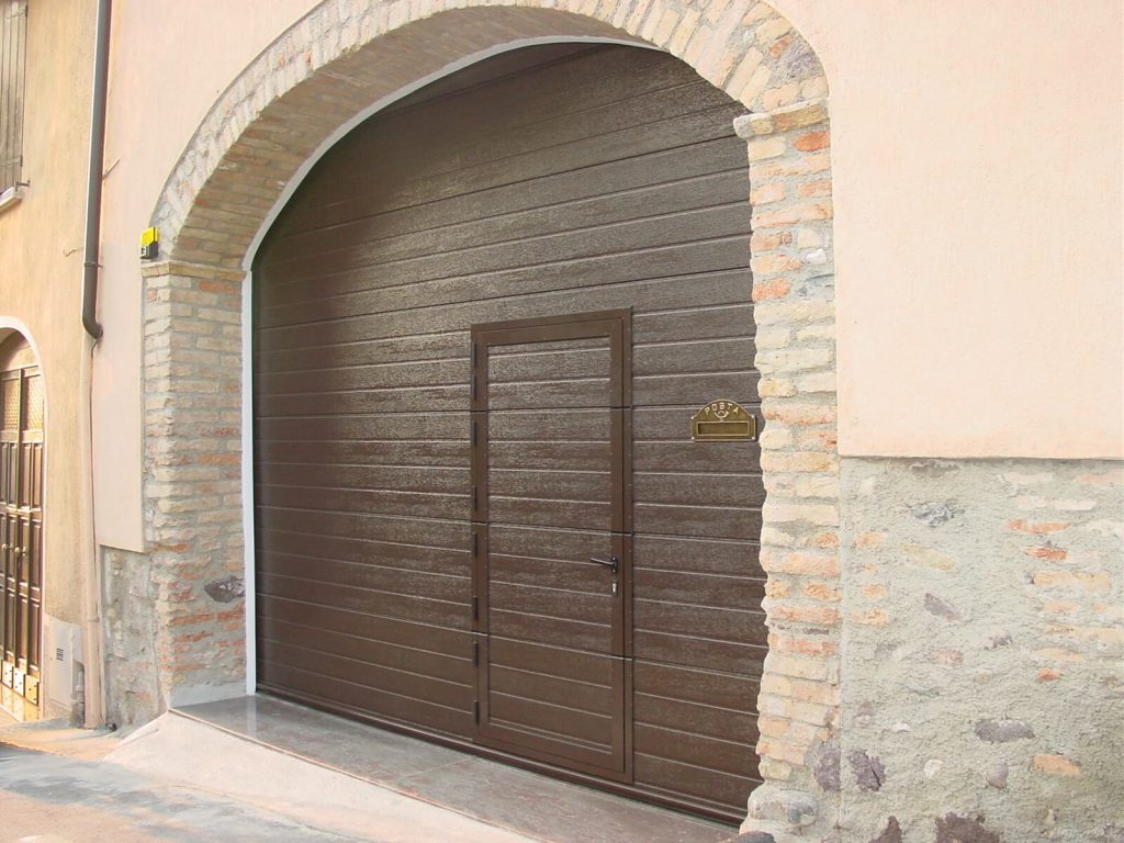 Porta per garage sezionale con porta pedonale a soglia ribassata e cassetta delle lettere integrata